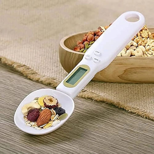 Digital measuring spoon with a bowl of mixed nuts and seeds on a wooden surface