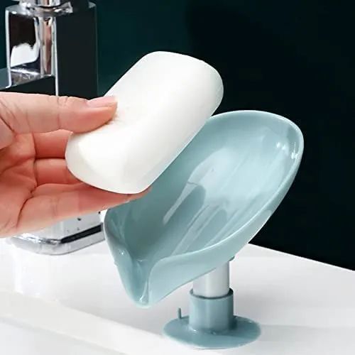 Hand holding a white silicone product over a blue silicone product on a white surface.