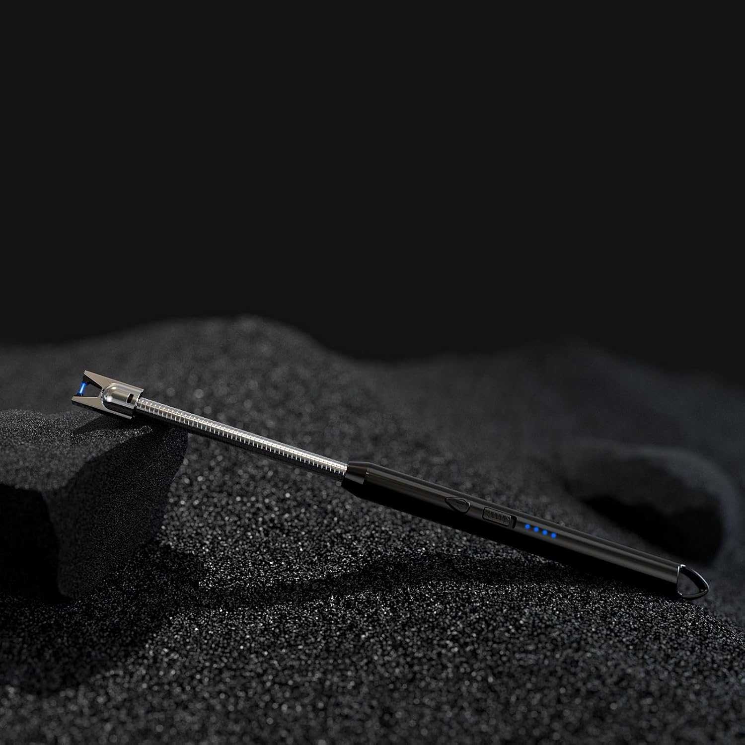 Metal tool on a textured black surface with a dark background